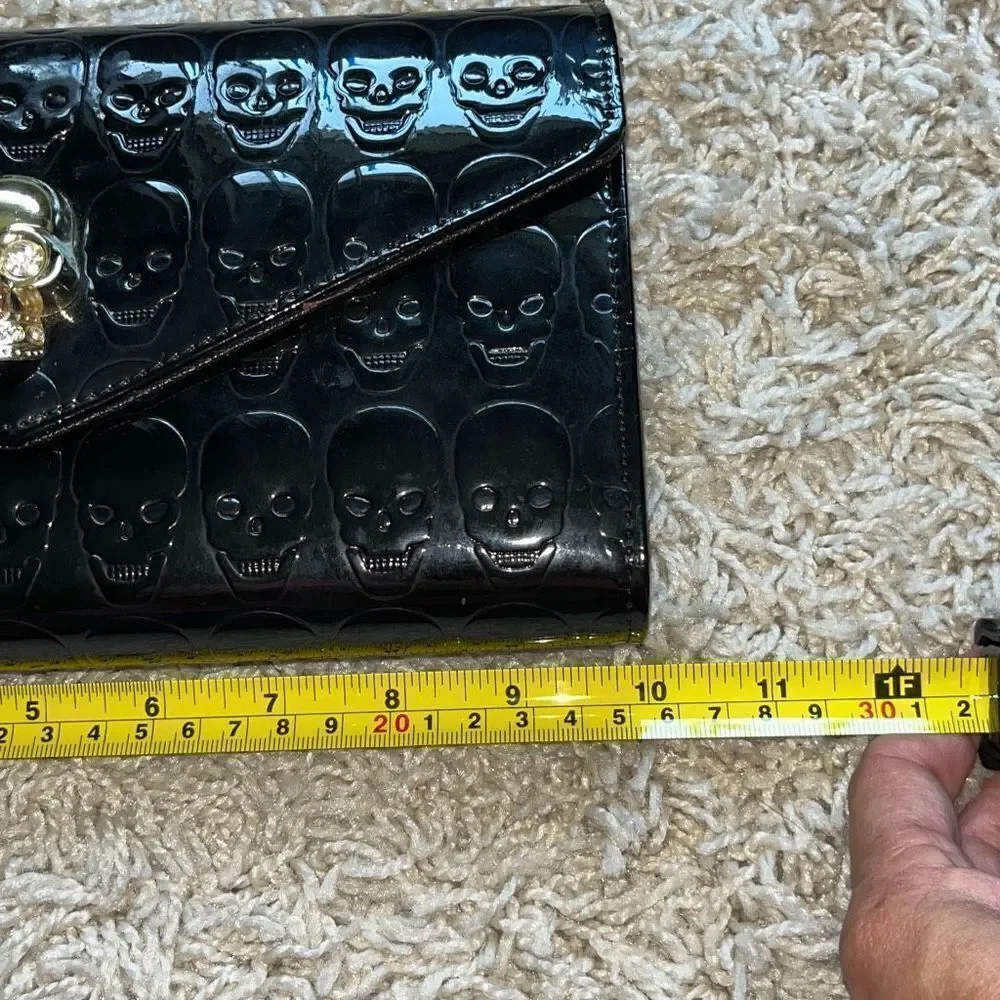Awesome patent leather skull embossed clutch bag with gold chain shoulder strap.